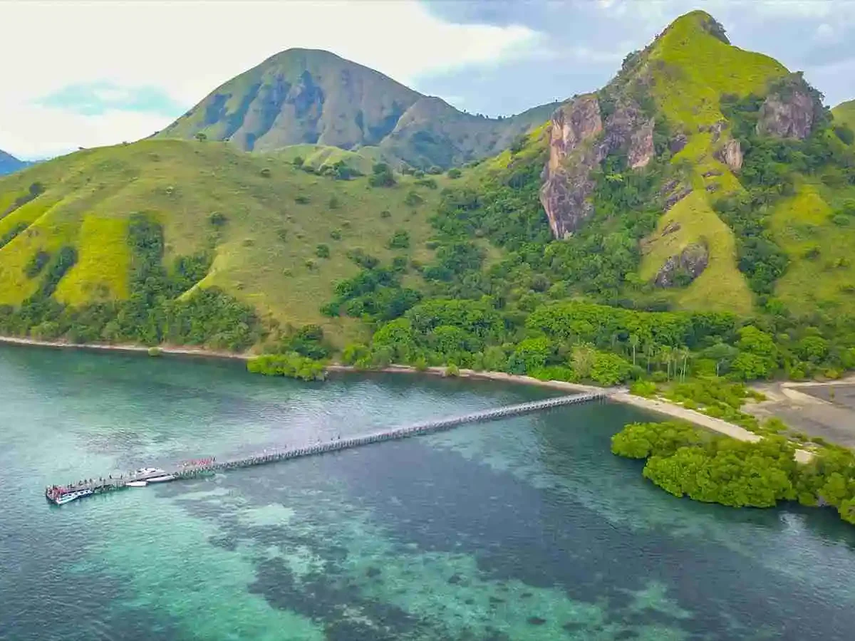 Liveaboard boats anchored beneath Padar Island's volcanic peaks