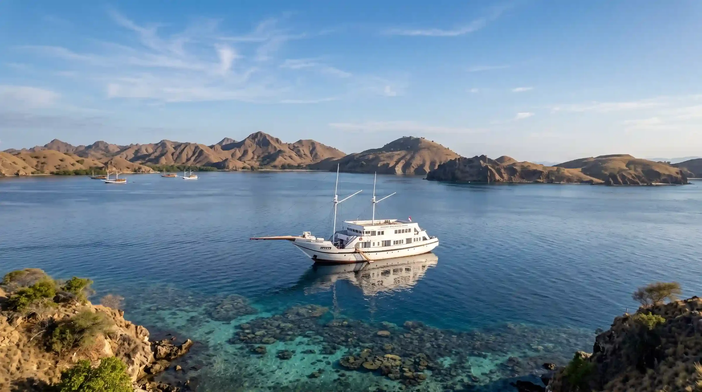 Aerial view of Lasha Phinisi Cruise anchored in a calm Komodo National Park bay
