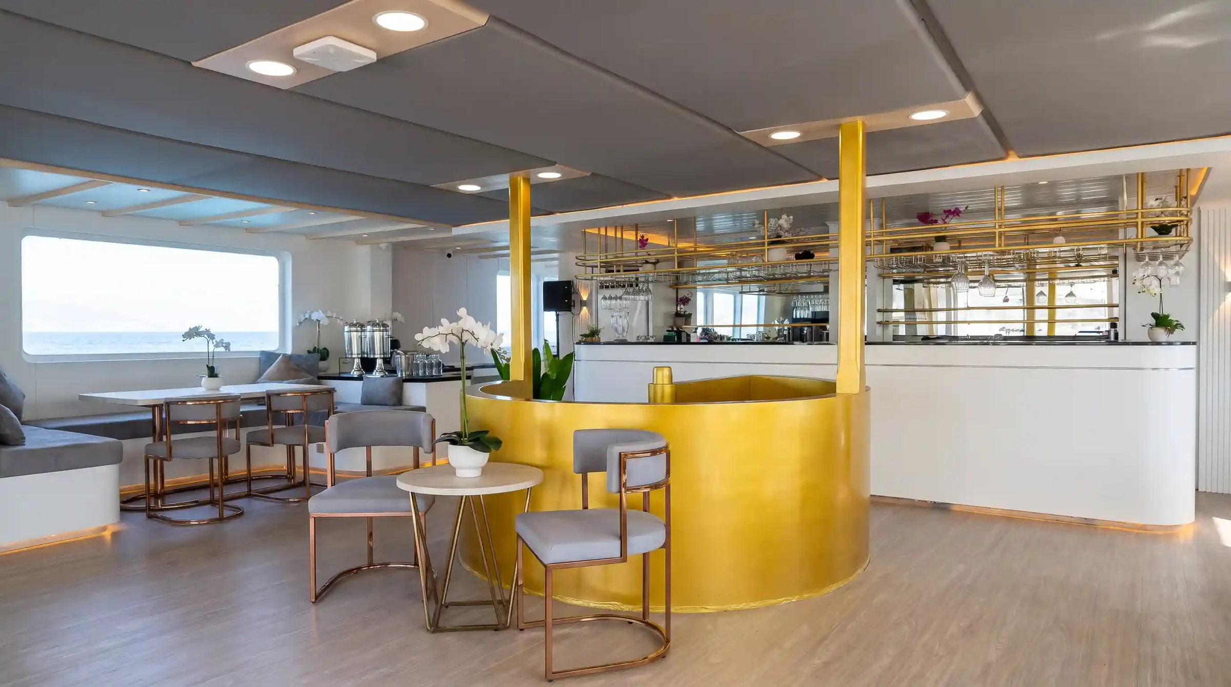Gold-accented bar and lounge on the upper deck of Lasha Phinisi Cruise