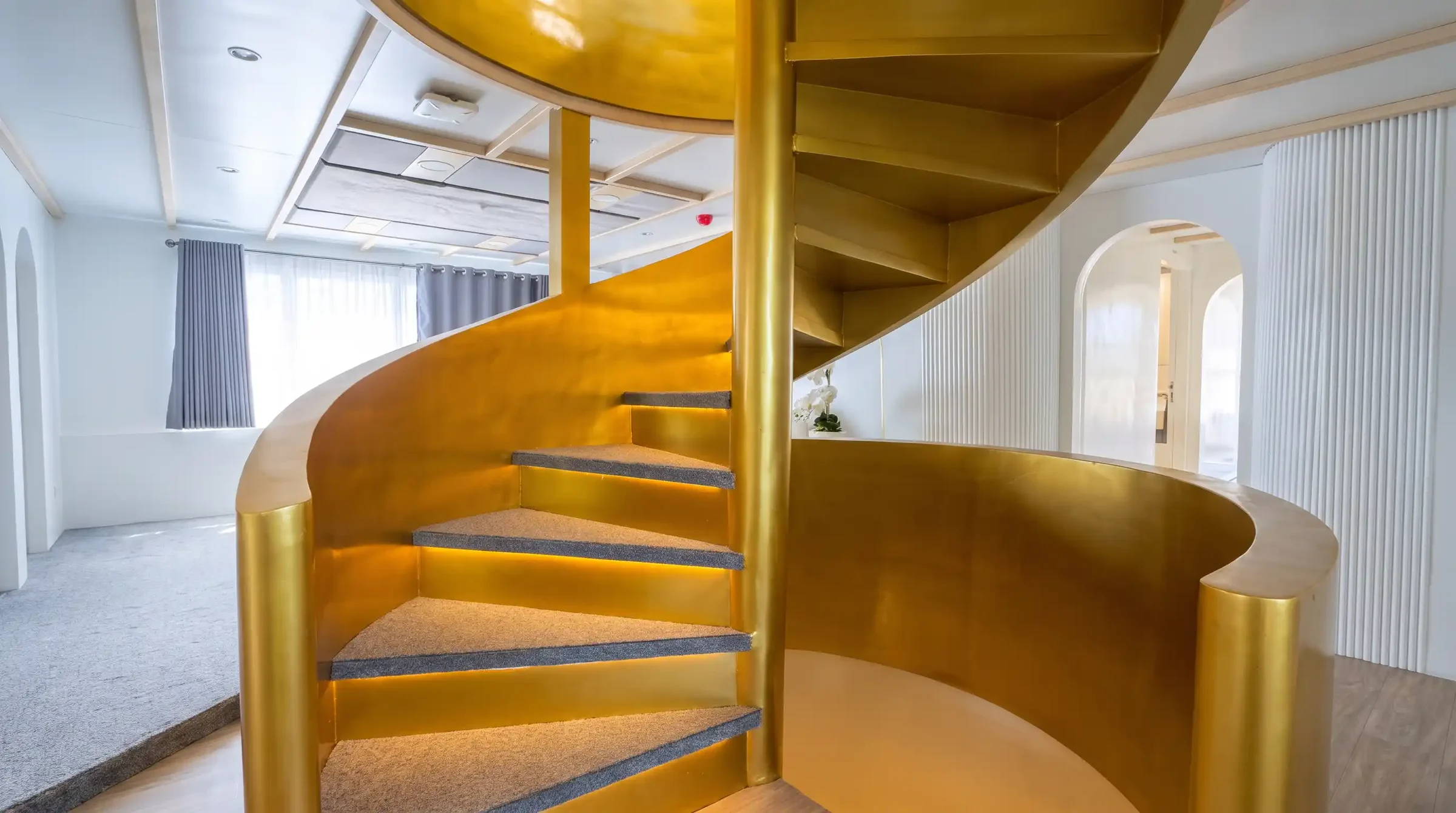 Brass spiral staircase connecting the decks of Lasha Phinisi Cruise