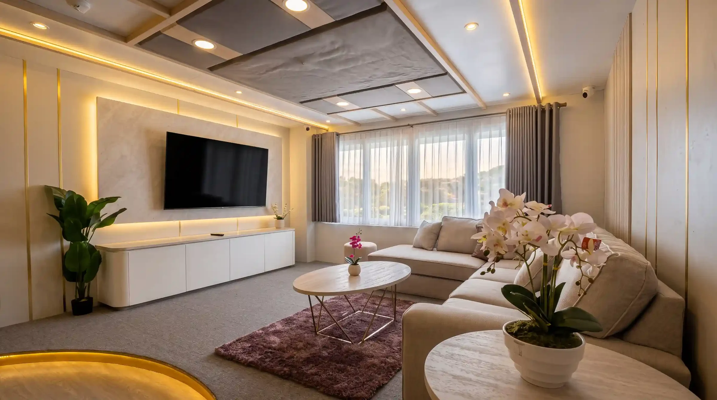 Living room lounge on Lasha Phinisi Cruise with sofa, television and orchid display